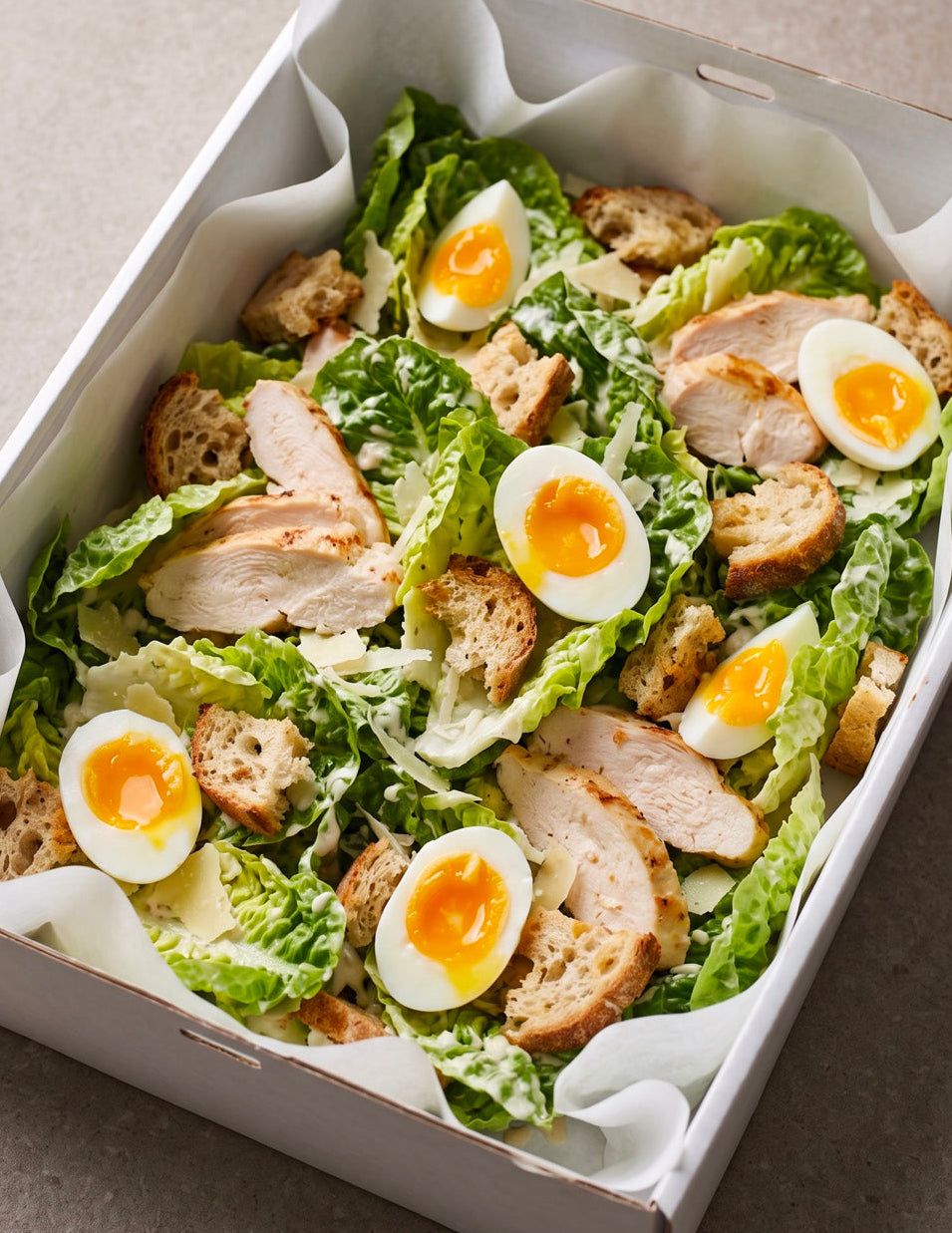 Chicken Caesar salad in Cibo's white catering tray