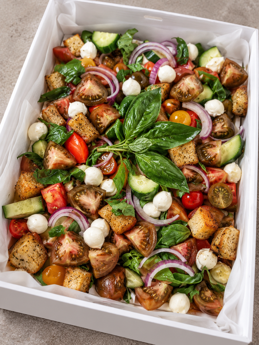 Panzanella salad in a white catering box